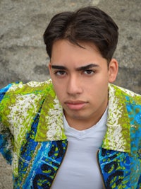 a young man wearing a colorful jacket