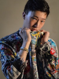 a young asian man in a colorful jacket